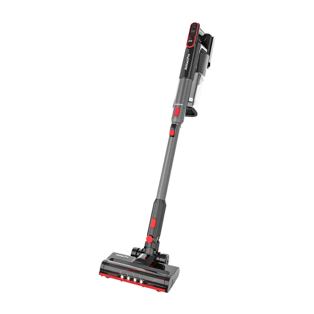 A cordless stick vacuum cleaner with a gray and black body and red accents, shown from a high angle on a plain white background.