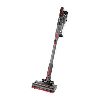 A cordless stick vacuum cleaner with a gray and black body and red accents, shown from a high angle on a plain white background.