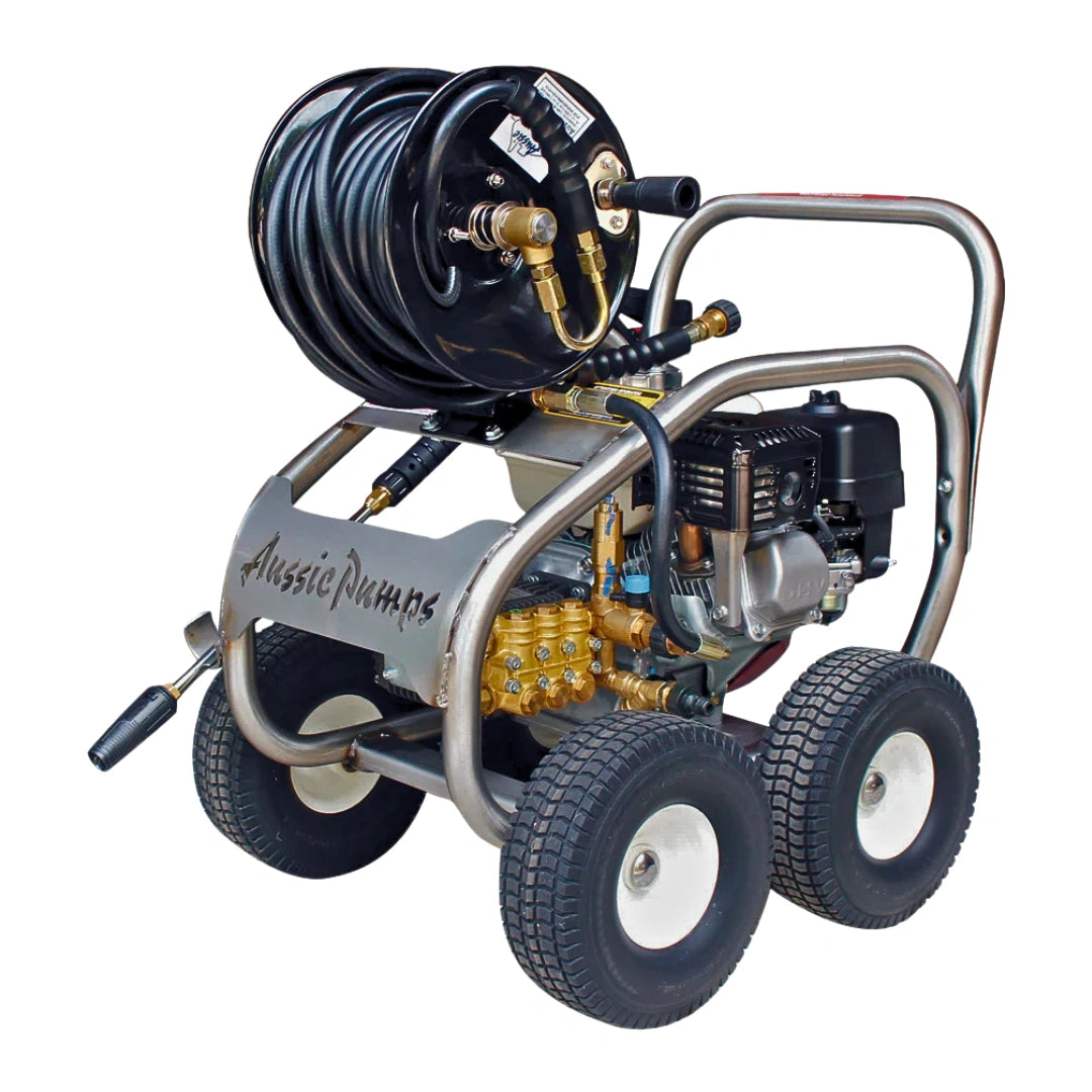 A high-pressure water washer with a black coiled hose, a black engine, and a silver metal frame with four wheels. The brand name 'Aussie Dumas' is printed on the side panel.