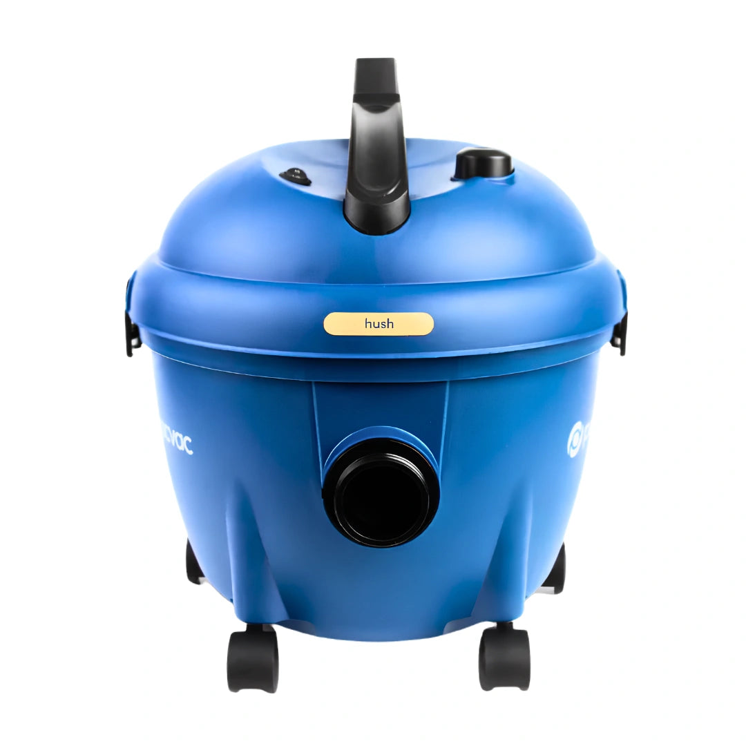 A blue wet/dry vacuum cleaner with black wheels, a black handle, and a small yellow label that reads 'hush'.