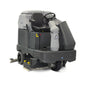 A commercial industrial floor cleaner with a gray and black body, featuring a high-visibility seat, steering wheel, and front-mounted scrubbing and sweeping brushes, shown on a white background.