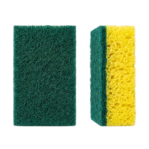 Two rectangular cleaning sponges on a plain white background: one dark green abrasive scrubber on the left, and one yellow porous sponge with a green side on the right.